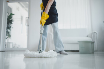 Cleaning staff mopping floors at home Wear an apron and rubber gloves to protect against cleaning...