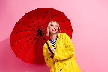 Photo of dreamy sweet woman dressed rain coat holding parasol looking empty space isolated pink...