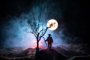 Silhouette of person standing in the dark forest with light. Horror halloween concept.
