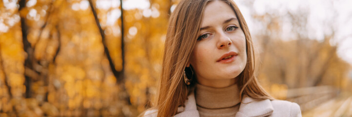 beautiful long-haired woman walks through the autumn streets. Railway, autumn, woman in a coat.