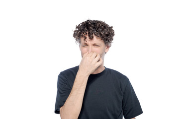 Middle-aged man holding his nose with his hand, as a gesture of bad smell, on a white background.