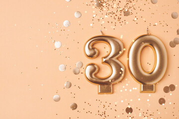 30 years celebration. Greeting banner. Gold candles in the form of number thirty on peach background with confetti.