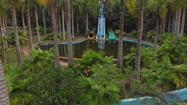 Old Abandoned swimming pool at Hue Vietnam with green vegetation around, aerial