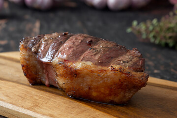 top sirloin rump cap or picanha on a marble background with rosemary,garlic and pepper