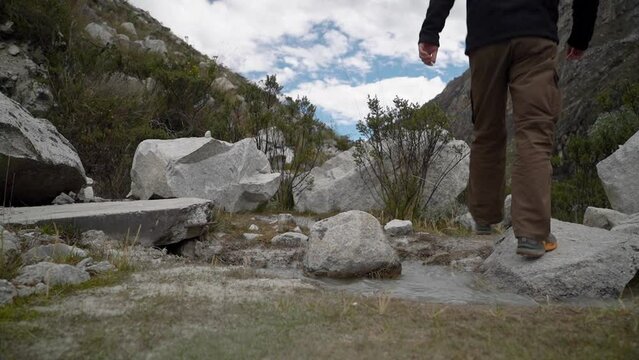 young caucasian man hiking through the mountainous landscape of the cordillera blanca in the Andes mountains of Peru near laguna Paron.