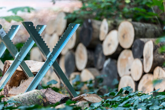 Ein Holzbock zum s&auml;gen mit Brennholz dahinter