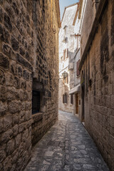 Morning walk along a romantic narrow street in the old town of Trogir on the Adriatic coast, Dalmatia, Croatia
