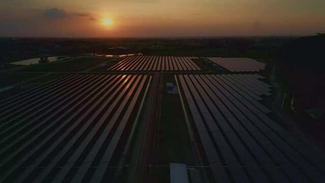 Aerial view of the solar cell farm, orange light.Eco Power Save Earth Solar power plant and 4K aerial view. Renewable energy. Green tech,