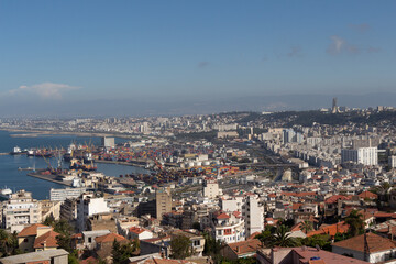 Fototapeta na wymiar Alger, Algiers, Algeria, 10 07 2023 : Beautiful panorama of the bay of Algiers with the industrial port and the Maqam Echahid monument : Martyrs Monument, in the background.