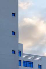 Urban abstraction : modern white building with purple windows and sky with an evening light.