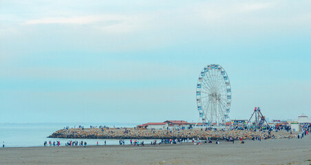 Algiers, Alger, Algeria : Ferris Wheel and people on the Sablettes beach and promenade  in the evening.