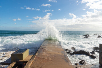 Sea wave crashing hard on a beach pier. Wild nature. Seasons