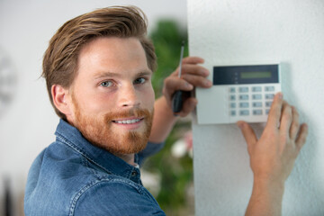 close-up of repairman installing security system against wall