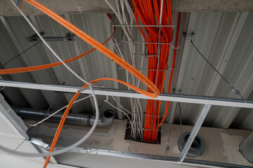 orange network cables run bundled under the ceiling.
