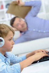Obraz premium Man poised to throw cushion at child to get his attention from computer