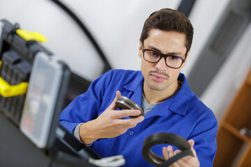 auto mechanic with instrument indoors