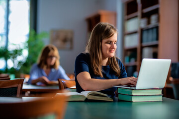 A visually impaired woman sitting and studying in the university library