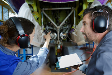 two modern aircraft engineers looking at airplane
