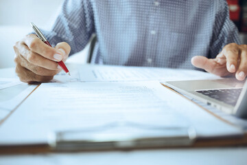 Asian businessman is analyzing documents, balance sheet management. form validation budget...