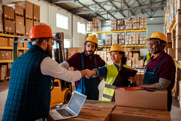 Warehouse manager handshaking a colleague after a successful shipment