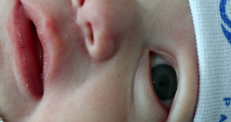 Naklejka premium Macro closeup of newborn face, baby infant eyes nose and mouth