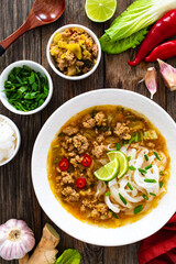 Yunnan rice noodle soup on wooden table
