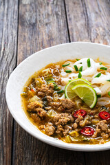 Yunnan rice noodle soup on wooden table

