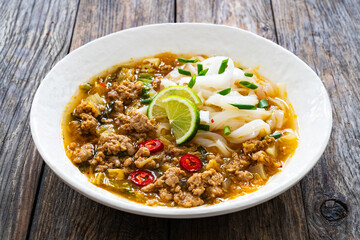 Yunnan rice noodle soup on wooden table
