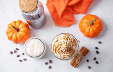 Pumpkin spice latte with whipped cream and cinnamon in a glass