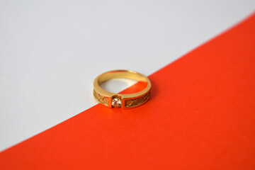 Close Up Golden ring with diamond on diagonal white and orange background