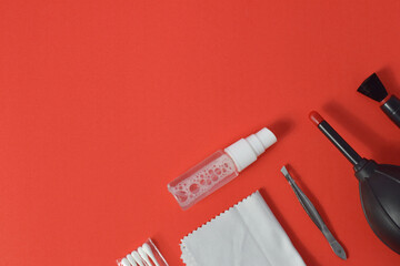 Cleaning set for camera air blower, microfiber, brush and more. Isolated on red background