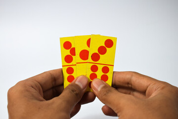 hand hold dominoes playing cards isolated white background, yellow red dominoes cards