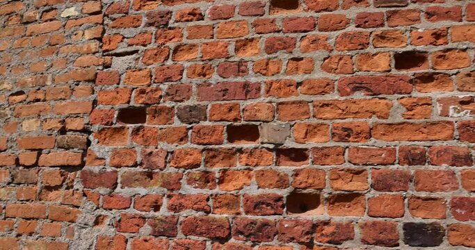 antique wall made of broken and cracked red bricks, combined antique wall made of different red clay bricks