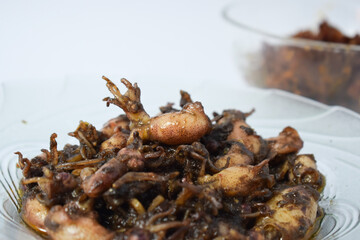 Close up Tumis Cumi, Oseng cumi or Stir Fried Squid placed on tranparent plate of glass isolated on white background. Indonesian food 