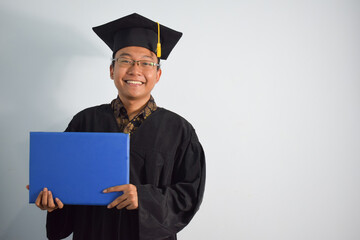 Expressive of Adult indonesia male wear graduation robe, hat and eyeglasses, Asian Male graduation bring blank blue certificate isolated on white background, expressions of portrait graduation