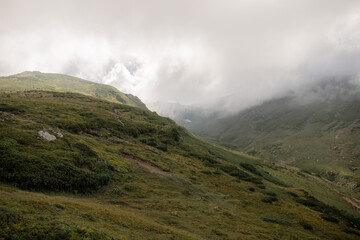 Cloudy day in the mountains: green hills and open space. High-quality photo for website design and travel product advertising