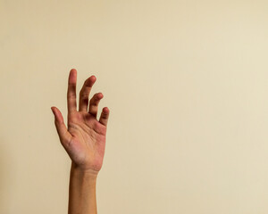 Abstract young woman's hand on brown background ,isolated number three.