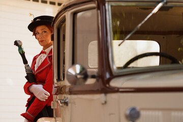 Mujer vestida de Mary Poppins detras de coche retro en la feria modernista Novelda 2023