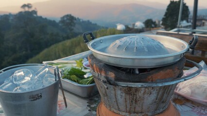 Moo Kata, a traditional Thai BBQ grill pork dish. The round hot pan with pork is grilled on top....