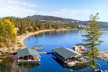 View from the Tubbs Hill hiking trail of the Sanders Beach lakefront community of homes, the sandy beach, and 11th Street Marina along the lake in Coeur d'Alene, Idaho USA at autumn. - obrazy, fototapety, plakaty