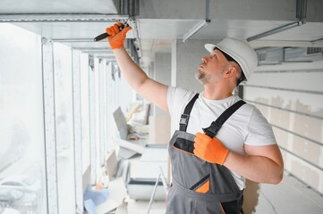 hvac services - worker install ducted pipe system for ventilation and air conditioning in office.