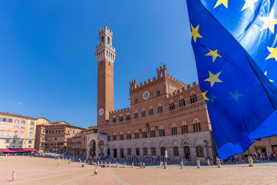 View of EU flags and Palazzo Pubblico in Piazza del Campo, UNESCO World Heritage Site, Siena, Tuscany