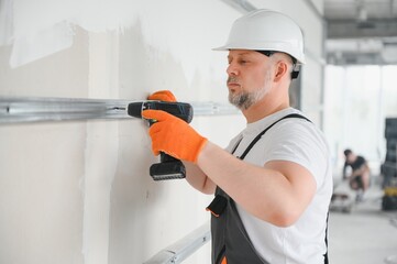Worker install a plasterboard wall