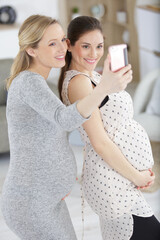 two pregnant friends are taking a selfie