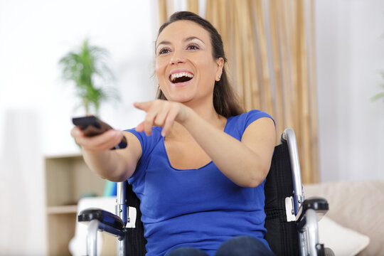 female in wheelchair elevision remote control pointing to tv