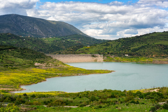 Zahara de la Sierra water reservoir dam with turquoise water and mountains in the background, Andalusia, Spain