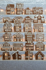 advent calendar out of 24 different home made gingerbread houses facade in rows illuminated with light from backside