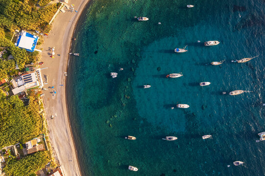 Aerial view of Palmarola bay with boats anchored in turquoise water at susnet, Palmarola island, Ponza municipality, Tyrrhenian sea, Pontine archipelago, Latina Province, Latium (Lazio)