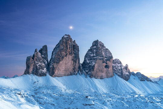 Moon above Tre Cime di Lavaredo at dusk, winter time, Tre Cime di Lavaredo (Lavaredo peaks) (Drei Zinnen), Sesto (Sexten), Dolomites, South Tyrol