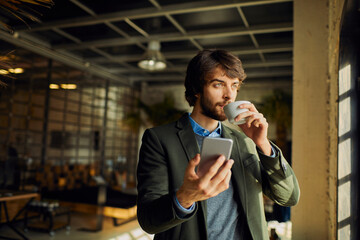 Young businessman using a smartphone on a coffee break in the office